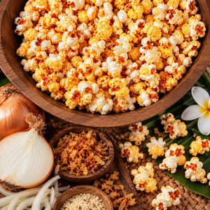 Maui Sweet Onion flavored popcorn in a rustic wooden bowl, surrounded by sweet onions and tropical decorations.